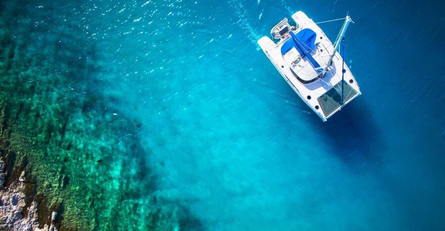 From Ornos: Mykonos Delos Catamaran Cruise with Meal & SUP - Rhenia’s clear water and quiet cove
