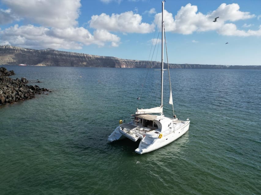 Santorini: Catamaran Cruise with Greek BBQ and Drinks - Red Beach and the southern coast
