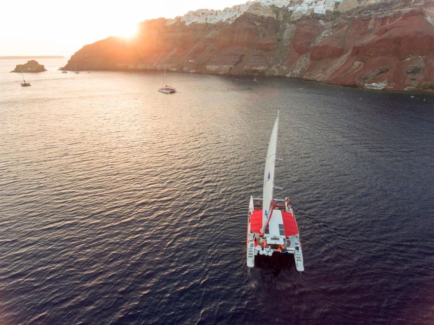Santorini: Cruise Catamaran with BBQ & Drinks Day or Sunset - The sunset option below Oia