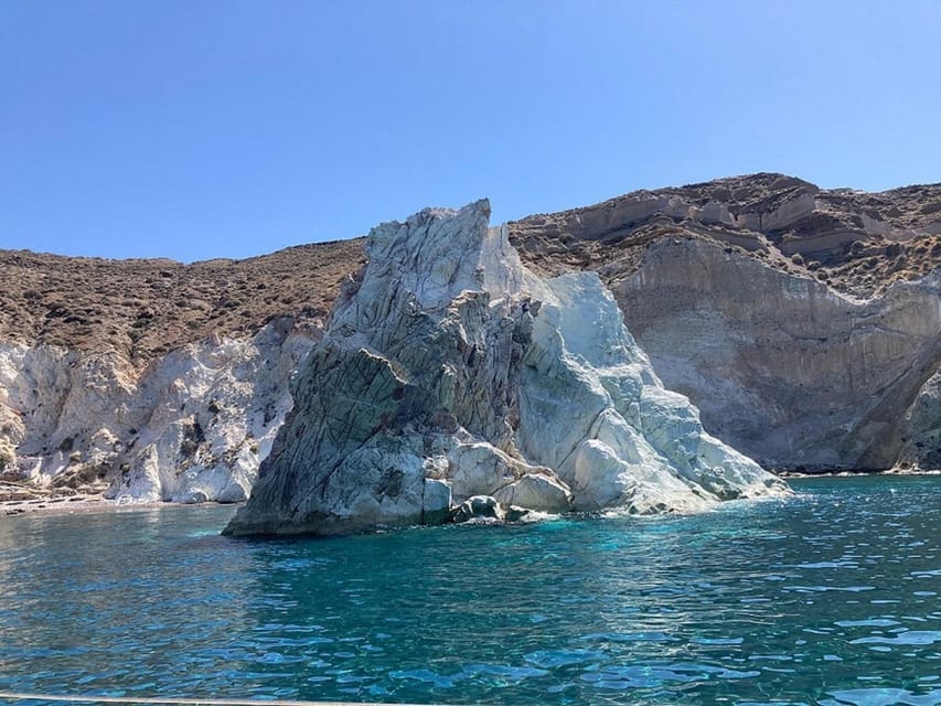 Santorini:Cruises with Catamaran around the Volcanic Island. - White Beach and the old lighthouse from the sea