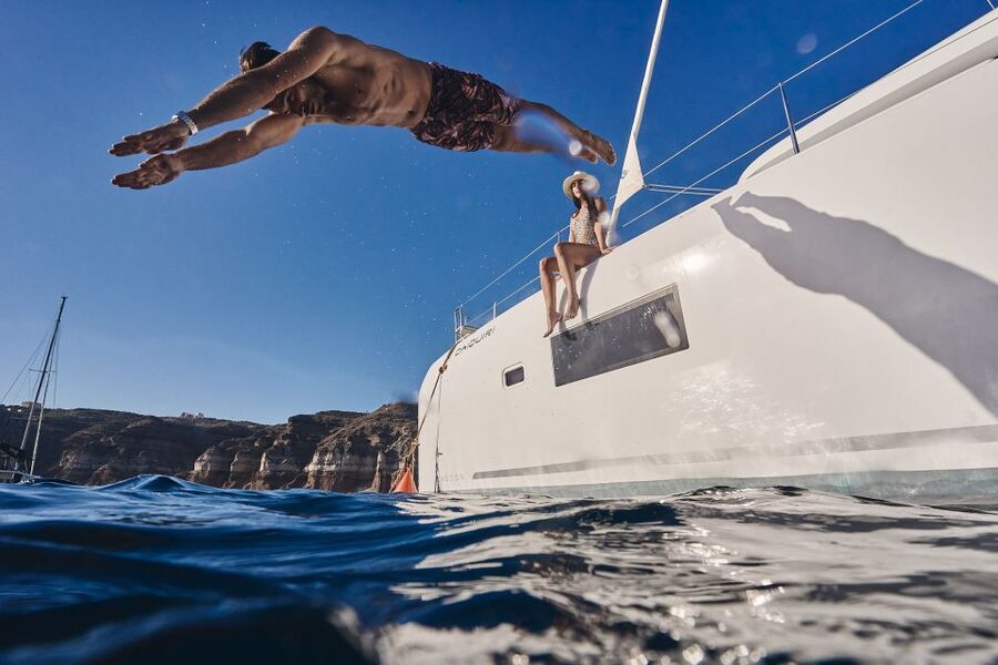Santorini: Day Luxury Catamaran Cruise with Meal & Drinks - Black lava rock around the volcanic islets