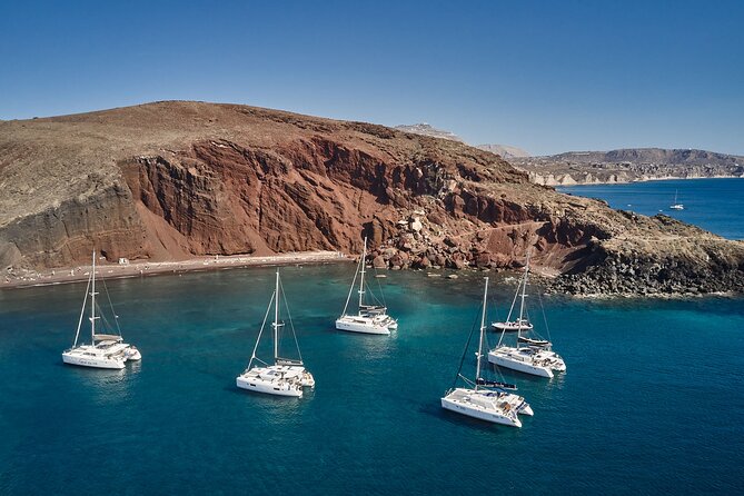Santorini: Luxury Catamaran Cruise with Fresh Fish BBQ & Drinks - Red Beach: red cliffs and a quick first swim
